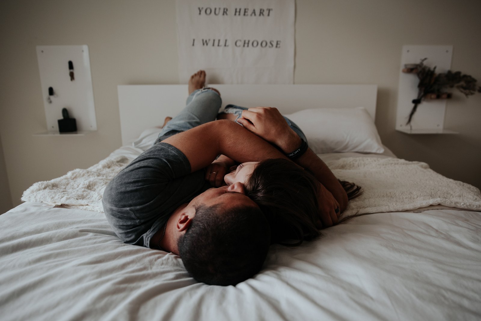 En man utan erektil dysfunktion eller potensproblem ligger i sängen bredvid en kvinna och båda kramar tillsammans.